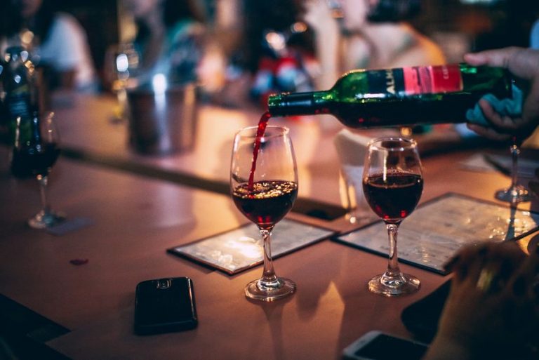 Prijatelji razgovaraju uz male čaše vina u konobi